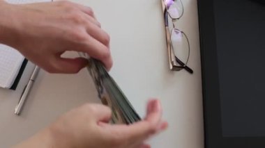 100 dolarlık banknotlar halinde paraları say.