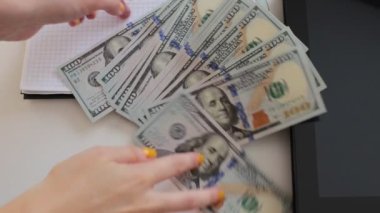 100 dolarlık banknotlar halinde paraları say.