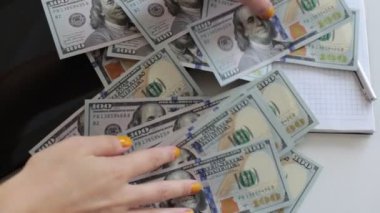 100 dolarlık banknotlar halinde paraları say.