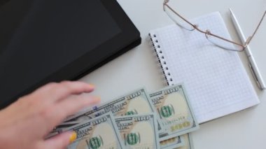 100 dolarlık banknotlar halinde paraları say.