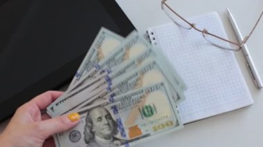 100 dolarlık banknotlar halinde paraları say.