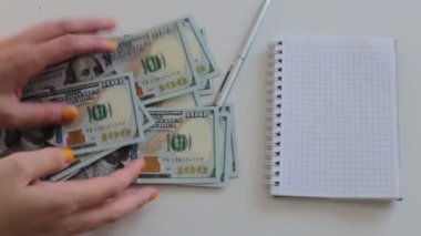 100 dolarlık banknotlar halinde paraları say.