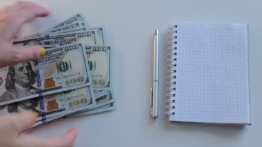 100 dolarlık banknotlar halinde paraları say.