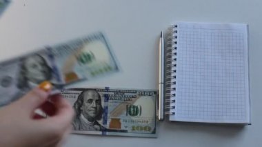 100 dolarlık banknotlar halinde paraları say.