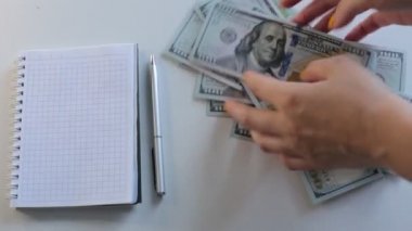 100 dolarlık banknotlar halinde paraları say.