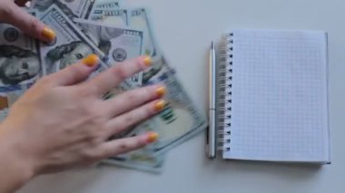 100 dolarlık banknotlar halinde paraları say.