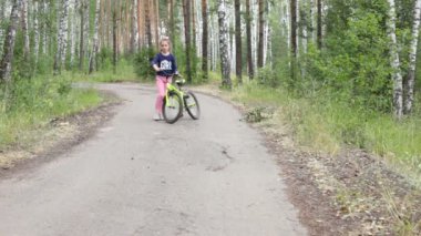 Sekiz yaşında bir kız yaz güneşli bir ormanda yürüyor.