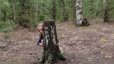 Sekiz yaşında bir kız yaz güneşli bir ormanda yürüyor.
