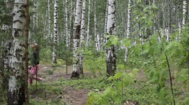 Sekiz yaşında bir kız yaz güneşli bir ormanda yürüyor.