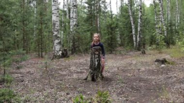 Sekiz yaşında bir kız yaz güneşli bir ormanda yürüyor.