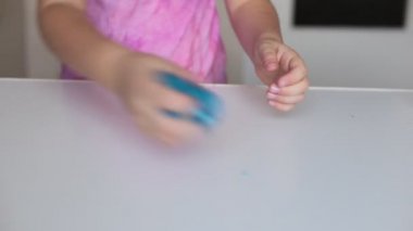 Sekiz yaşındaki kız çocuklar arasında popüler olan sümüklü şekerle oynuyor.