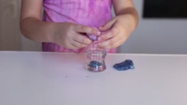 Sekiz yaşındaki kız çocuklar arasında popüler olan sümüklü şekerle oynuyor.