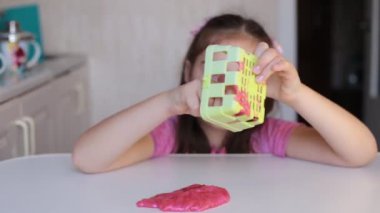 Sekiz yaşındaki kız çocuklar arasında popüler olan sümüklü şekerle oynuyor.