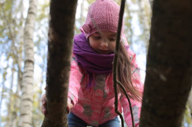 Ormanda sonbahar yürüyüşü yapan bir kız.