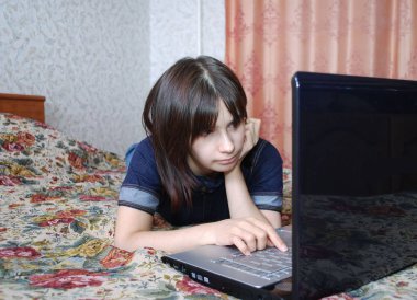 Yatakta dizüstü bilgisayarı olan kız