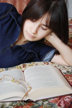 Kız yatakta yatıyordu bir kitap okuma