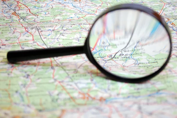 Magnifying glass lying on a paper map of Russia