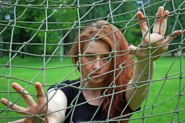 Genç Sevimli kız futbol gol net bakarak. Izgaraya odaklan, yüz bulanık. Renkli fotoğraf.