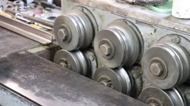 Usta Tinsmith bakırın gelecekteki ürününü katlama makinesine sarar. Üretim. El yapımı iş.