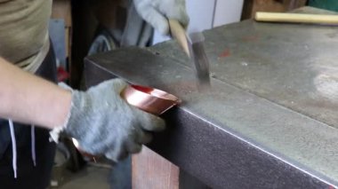 Usta kalaycı, bakır bir borunun bağlantı kilidini elle açıyor. Üretim. El yapımı iş.