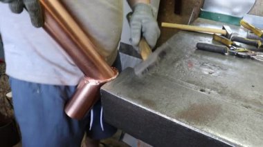 Usta kalaycı semaver için bakır borunun bağlantı kilidini elle kırıyor. Üretim. El yapımı iş.