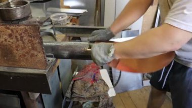 Usta Tinsmith boruya eğiliyor ve bakırdan yapılmış gelecekteki ürünün detaylarına giriyor. Üretim. El yapımı iş.