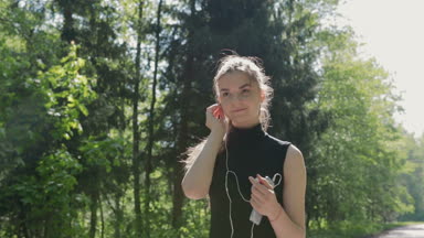 Genç bir esmer kulaklık yapar ve koşu başlatır