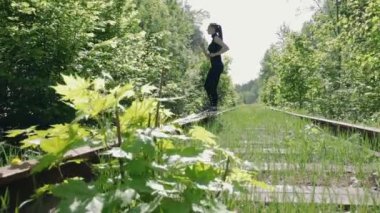 Siyah elbiseli Genç esmer fiziksel egzersizler bir terk edilmiş tren arka plan üzerinde gerçekleştirir.