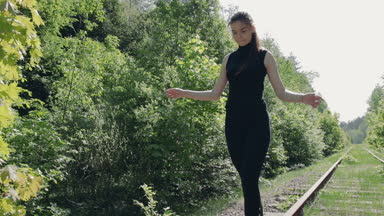 Siyah elbiseli Genç esmer eski Demiryolu demiryolu üzerinde olduğunu. Kız bir denge holding