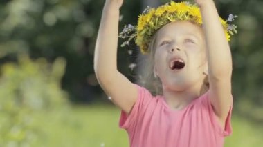 Ormanın içinde garip bir küçük kız portresi. Bir çocuk ön dişler gülümsüyor ve önüne gelenle olmadan dandelions çelenk başını düşüyor.