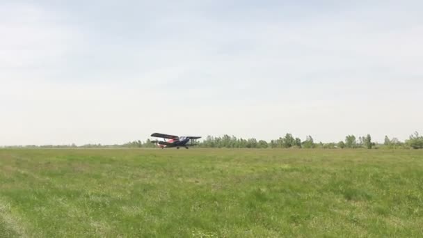 Leichtes einmotoriges Flugzeug hebt vom grünen Feld in den Himmel ab — Stockvideo