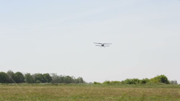Ελαφρύ μονοκινητήριο αεροσκάφος προσγειώνεται στο αεροδρόμιο του πεδίου. Το αεροσκάφος βρίσκεται στο καταπράσινο γρασίδι — Αρχείο Βίντεο