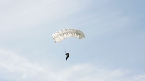 Человек чрезвычайно спускается с парашютом на землю. Парашютный полёт — стоковое видео