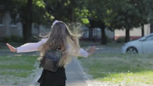 Porträtt av en blond Skolflicka 1-2 klass med en portfölj — Stockvideo