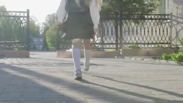制服と彼女の肩の上のブリーフケースで少し面白い女子高生は 学校に実行されます ステディカム ショット — ストック動画