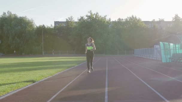 Bella ragazza del fitness che corre sul tapis roulant. Giovane atleta in allenamento — Video Stock