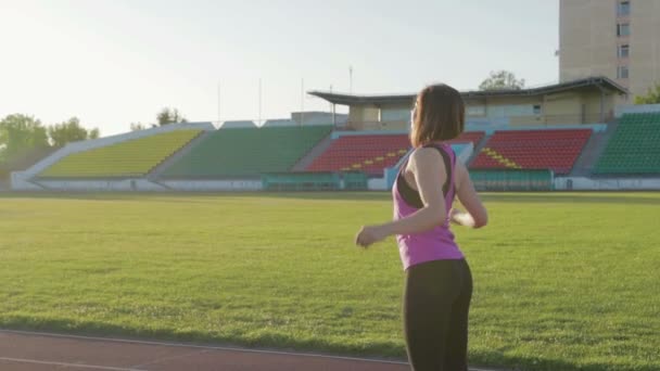 Hermosa chica fitness calentándose antes del comienzo. Joven atleta en entrenamiento — Vídeo de stock