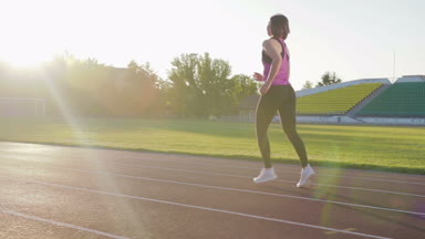 Stadyum koşu bandı üzerinde çalışan güzel fitness kız. Eğitim genç atlet