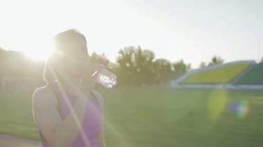 Güzel fitness kız içme suyu bir şişe bir egzersiz sırasında