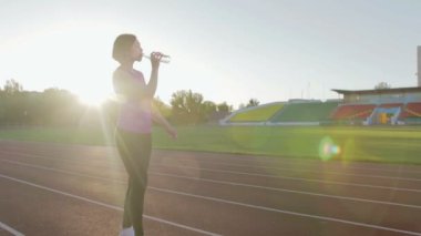 Güzel fitness kız içme suyu bir şişe bir egzersiz sırasında