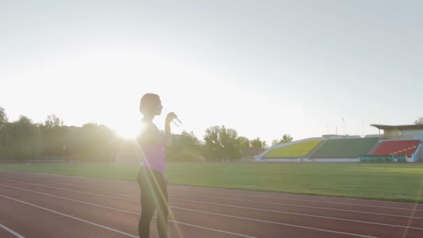 Vackra fitness tjej dricksvatten från en flaska under ett träningspass — Stockvideo