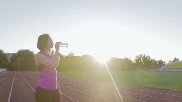 美丽的健身女孩在锻炼过程中喝水的瓶子 — 图库视频影像