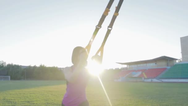 Hermosa chica de fitness entrena en el estadio. Un joven atleta se dedica a bucles en el campo en el gol de fútbol — Vídeo de stock