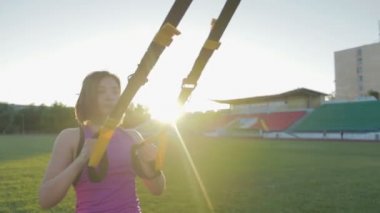 Güzel fitness kız stadyumda eğitiyor. Genç bir atlet futbol gol alanında döngüler ile nişanlandı