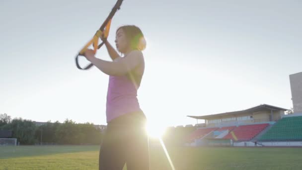 Hermosa chica de fitness entrena en el estadio. Un joven atleta se dedica a bucles en el campo en el gol de fútbol — Vídeo de stock