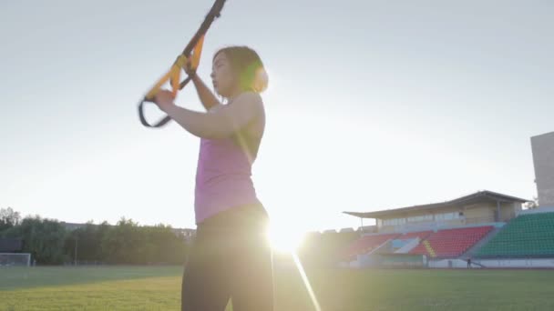 Bela menina de fitness treina no estádio. Um jovem atleta está envolvido com loops no campo no gol de futebol — Vídeo de Stock