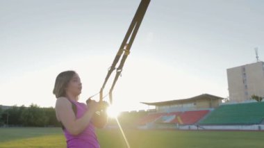 Güzel fitness kız stadyumda eğitiyor. Genç bir atlet futbol gol alanında döngüler ile nişanlandı