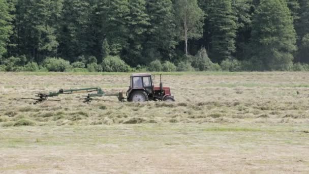 Le tracteur tourne le râteau à foin mécanique — Video