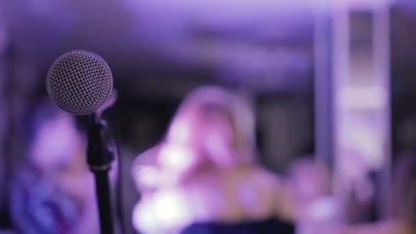 Primer plano del micrófono negro, celebración de fondo borroso, bokeh, karaoke — Vídeo de stock