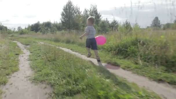 Маленький мальчик с воздушным шаром — стоковое видео